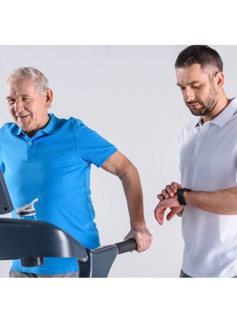 A physiotherapist timing an older man as he runs on a treadmill
